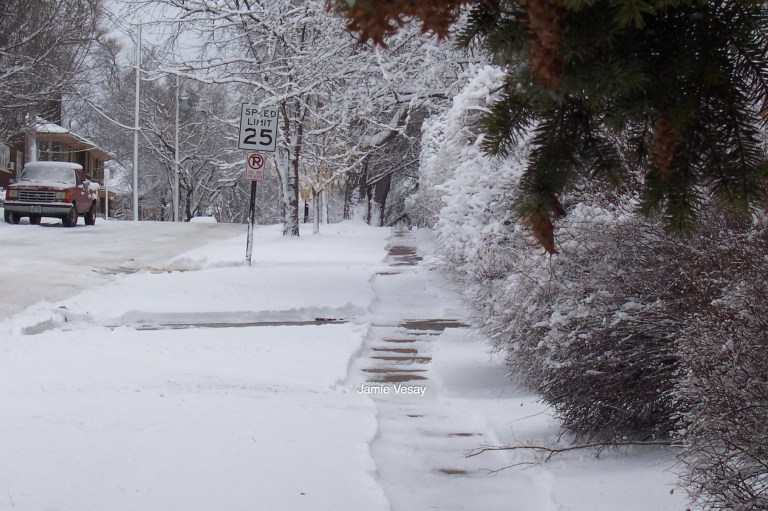 Snow in a neighborhood. Shovels and plows.